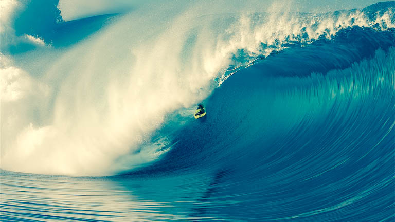 “A pro surfer stays ahead of a huge wave”